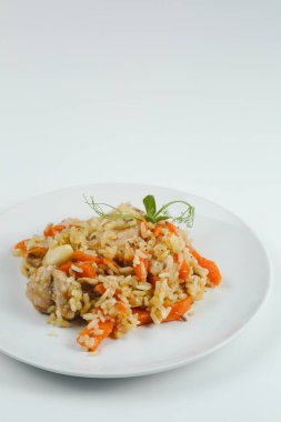 Tavuklu pilav ve havuç. Beyaz tabakta yakın plan. Beyaz arkaplanda tavuk pilavı.
