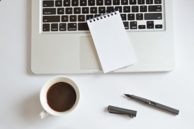 Kahve fincanı, spiral defter, bilgisayar klavye ve kalem beyaz