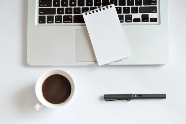Šálek kávy, spirála notebook, počítačové klávesnice a pera na bílém pozadí — Stock fotografie