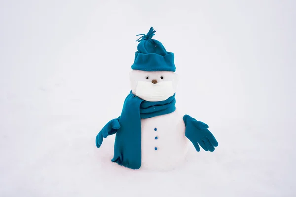 Sneeuwman met gezichtsmasker, winterhoed. sjaal op een witte achtergrond — Stockfoto