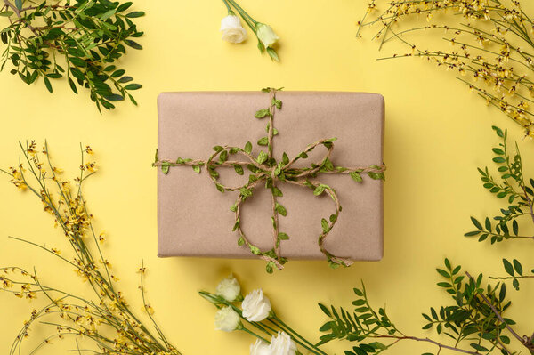 Прекрасная весна, летняя композиция. Подарочная коробка и рама с цветами, листьями на желтом фоне.