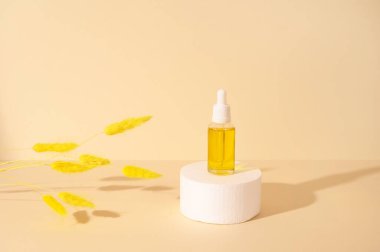Ürün sunumu için bej renkli pastel arka planda kozmetik şişesiyle beyaz yuvarlak podyum. Ön görünüm.