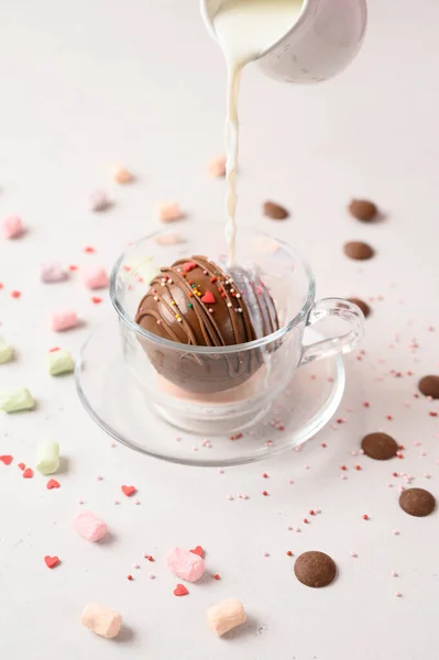 Bomba de cacau que derrete com leite quente. Xícara de chocolate quente escuro. Comida de conforto. Mesa de madeira branca com pano verde e decoração de Natal. Ótimo para estação fria. Fotos De Bancos De Imagens