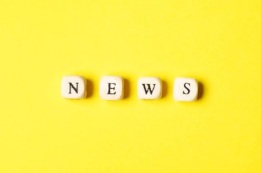 Sarı arka planda ahşap haber işareti. Pozitif kavram.