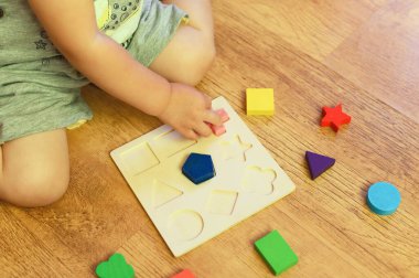 Çocuk çok renkli bir ayırıcı topluyor. Çocuklar için eğitici mantık oyuncağı