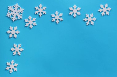 Yaratıcı Noel veya Yeni Yıl kompozisyonu. Yukarıdan bak. Arka plan ahşap oyuncaklar ve kopya alanı ile mavi. Tebrik kartı modeli. Düz yatıyordu.