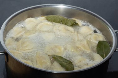 Ev yapımı hamur köfteleri kaynar suyla birlikte bir tencerede kaynatılır. Yakın plan.