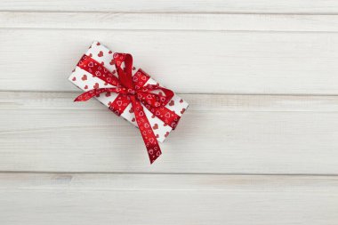 Beyaz ahşap arka planda bir hediye kutusu. Yukarıdan bak. Boşluğu kopyala.