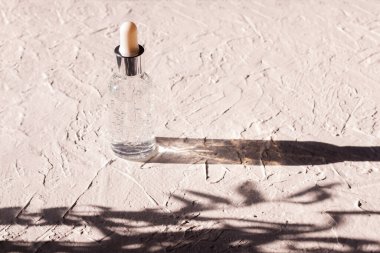 Serumla birlikte cam şişe ya da yüz ve vücut için yağ. Doğal organik kozmetik ürünleri konsepti. Parlak sert ışık. Bir yazıt için yer.