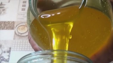 Bir kavanoza bal dökme süreci. Sarı, tatlı ve yapışkan ürünün nakli