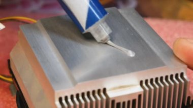 Termal macunun bir tüpten PC soğutma radyatörüne uygulanması ve dağıtımı. Aşırı ısınan ekipmanların önleyici onarım ve imhası sürecine yakın çekim