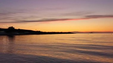 Ufukta bir gemiyle denizde turuncu gün batımı. Sessiz, huzurlu bir akşam manzarası. Seyahat ve eğlence kavramı. Tam sakin ve küçük dalgalar. Sivastopol, Kırım 'daki sahil.