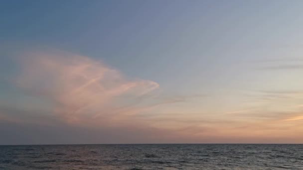 日没時の風景 海の上にカラフルなオレンジ色の夕日 夏の夜の空気 夕暮れ時の静かな波 暖かい日没の光の中で劇的な空 岩に打ち寄せる波 — ストック動画
