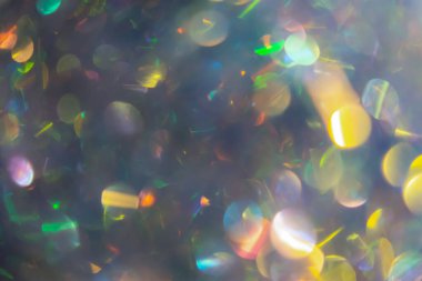 Çok renkli Bokeh 'ten yapılan soyut tatil arka planı. Noel, yeni yıl ve doğum günü için gümüş efektli parlak parlak inci. Parlak süslemeden yapılmış hologram süsü.