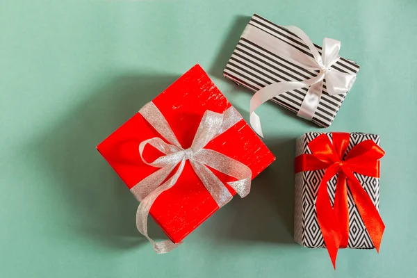 緑の背景にクリスマスプレゼント タイ弓上のビューを持つ異なるパックボックス お正月もクリスマスも 買い物や休日への贈り物という概念です — ストック写真