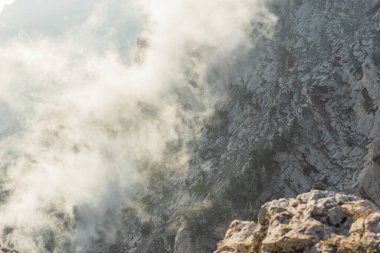 Dağlar, orman, bulutlar. Güzel, şeffaf bulutlar kozalaklı ormanın üzerindeki dağların altında yüzerler. Doğayla bütünlük kavramı. Kopyalama alanı olan doğal arkaplan