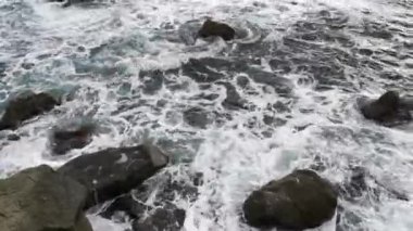 Gri köpüklü deniz ve kayalar. Fırtınadan önceki korkunç Karadeniz. Dalgalar gelir ve kayalık sahilde kırılır. Üst Manzara. Büyüleyici deniz suyu sıçraması. Umutsuzluk, depresyon kavramı