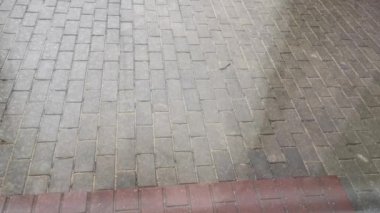 Evin yakınındaki kaldırıma küçük bir dolu düşüyor. Dışarıda hava kötü. Gök gürültüsü konsepti. Beyaz donmuş yağmur damlaları gökten düşer ve yerde erir. Soğuk kasırga