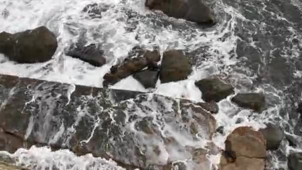 바다와 파도는 바위가 해안으로 흘러들어 옵니다 위에서 바닷물을 튀기고 있었습니다 — 비디오