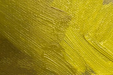 Tablo üzerinde kahverengi ve sarı yağlı boya olan soyut bir arkaplan. Tablodaki fırça darbelerinin yakın çekimi. Zeytin, ahtapot, limon sarısı boya. El yapımı branda desenli arka plan tasarımı. Yağlı boya.