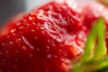 Çilekli makro doku. Kırmızı olgun meyvelerin arka planı. Lezzetli sulu çilekler seçici bir odak noktasında kapanıyor. Yaz konsepti, tazelik, vitaminler. Doğal gıda geçmişi. Vejetaryenlik