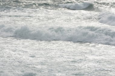 Pastel grisi deniz. Öfkeli bir okyanusun dokusu, yazı için geniş çerçeveli. Hava durumu, tatil, seyahat. En saf temiz deniz suyu, büyük dalgalar yakın çekim. Sakin doğal açık gri arkaplan