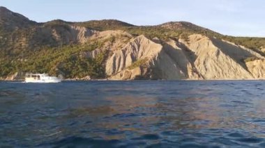 Balaklava Kırım 9 Ağustos 2020. Hızlı hareket eden bir teknenin manzarası. Dağların arka planında turist eğlence teknesi. Ufuktaki manzara çok güzel. Hareketli çekim, dalgaların yakın çekimi