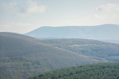 Dağlar mavi dumanlı manzara. Güzel atmosferik sabah sisli ormanı. Tarafsız, soğuk, doğal bir geçmiş. Mavi sisli dağların çizgileri. Sessizlik, sükunet, doğayla bütünlük kavramı..