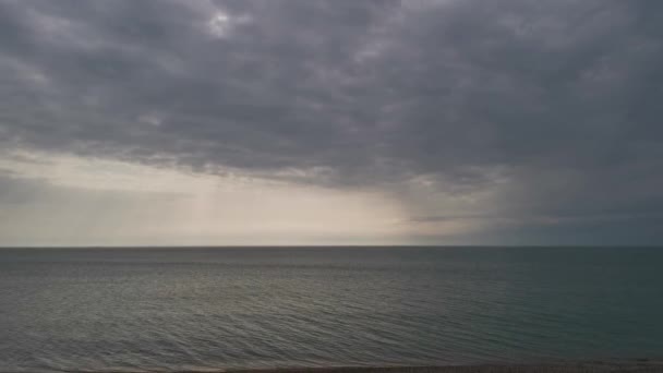 海は曇りの空です 灰色の雲がゆっくりと海の地平線上に浮かんでいます 雨の前の空 灰色の曇りの日の概念 人のいない寂しいビーチ 秋の恐慌 — ストック動画