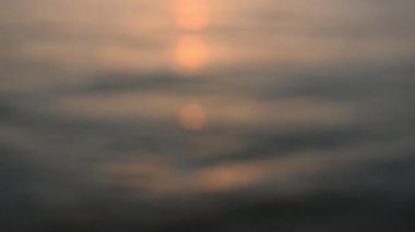 Denizde odaksız altın gün batımı. Güzel turuncu güneş ve su parlıyor. Soyut yatay titreşimli doğal arka plan, yaz havası için. Denizin yüzeyinde altın güneşli bokeh