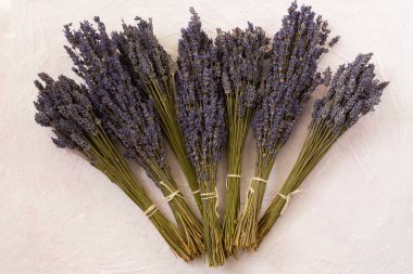 Açık pembe ahşap arka plan manzaralı kuru lavanta. Kokulu yaz çiçeklerini toplamak ve kurutmak. Satış öncesi hazırlık. Aromaterapi, kozmetoloji, alternatif tıp kavramı. Düz yatıyordu