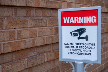 Özel güvenlik kameraları uyarı işareti uyarısı. Bu kaldırımdaki tüm aktiviteler dijital gece görüş kameraları tarafından kaydedildi.