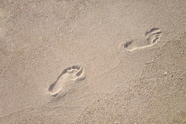 human foot prints on sand beach