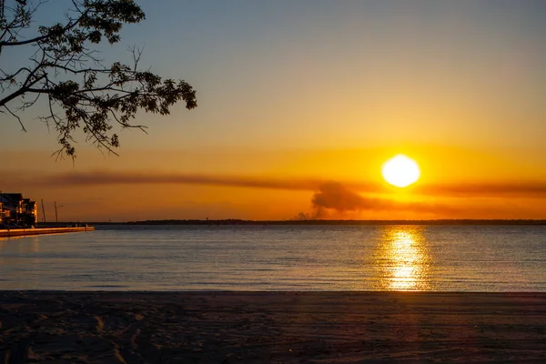 line of homes along the water bay with the hot sun rise sun set orange yellow light