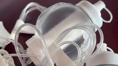 Bir grup temiz elastomerik infüzyon pompaları pürüzsüz ahşap bir yüzeye dayanır, her biri su deposunu doldurur ve görünür bir tüp takar, tıbbi malzeme veya tedavi görselleri için temiz bir klinik düzen oluşturur..