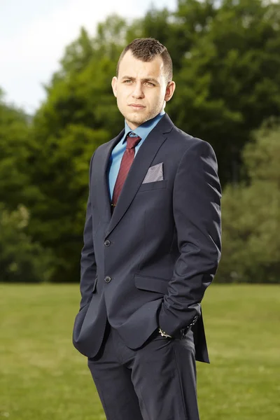 Man in suit posing in park — Stock Photo, Image