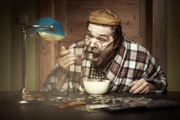 Man eating a lot of coins — Stock Photo, Image