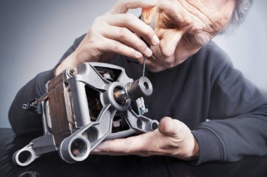 Çamaşır makinesini kontrol eden ve ölçen adam