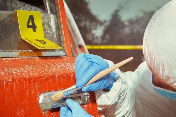 警察の技術者が詳しく調べた犯罪者によって焼かれた古い赤い車 — ストック写真