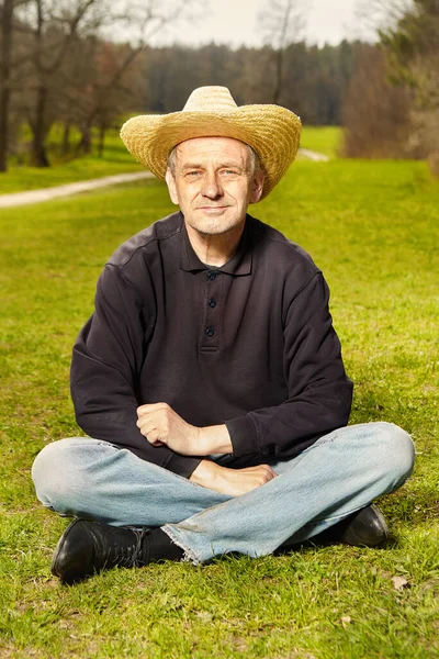 Natürlicher Älterer Mann Dunklem Hemd Und Strohhut Entspannt Sonnigen Park — Stockfoto