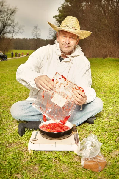 Natural older man in dirty white shirt preparing strawberry fruit lunch