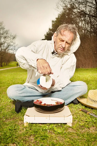 Natural older man in dirty white shirt mixing strawberry fruit lunch