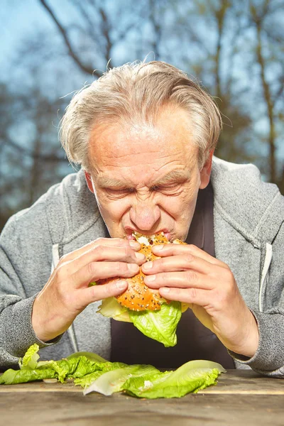 Mann Öffentlichen Stadtpark Genießt Und Isst Sein Hamburger Essen — Stockfoto