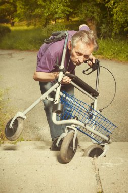 Older man overcoming obstacles with his four wheel rollator walker