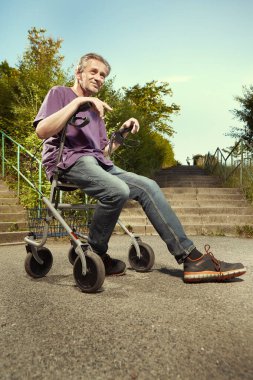Older man overcoming obstacles with his four wheel rollator walker