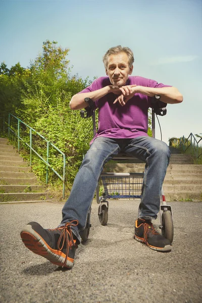 老年人用他的四轮滚动式步行机克服障碍 — 图库照片