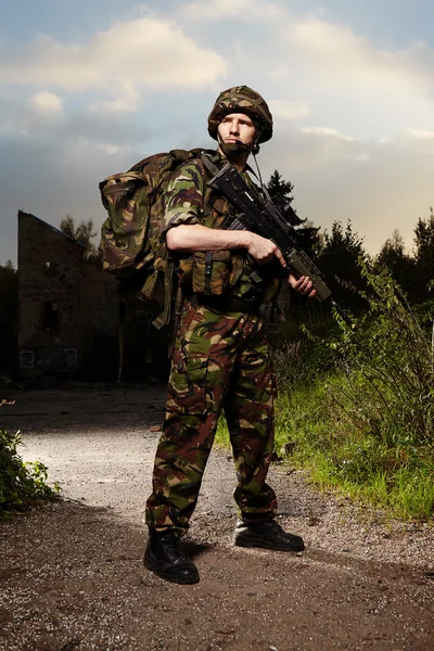 Armed soldier with kitbag on patrol — Stock Photo, Image
