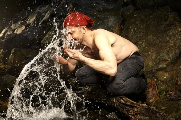 Man refreshing itself in autumn creek — Stock Photo, Image