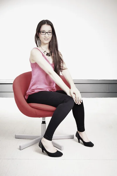 Model on red chair in summer light — Stock Photo, Image