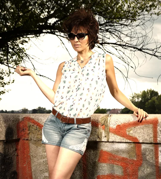 Jolie femme avec des lunettes de soleil posant en plein air — Photo